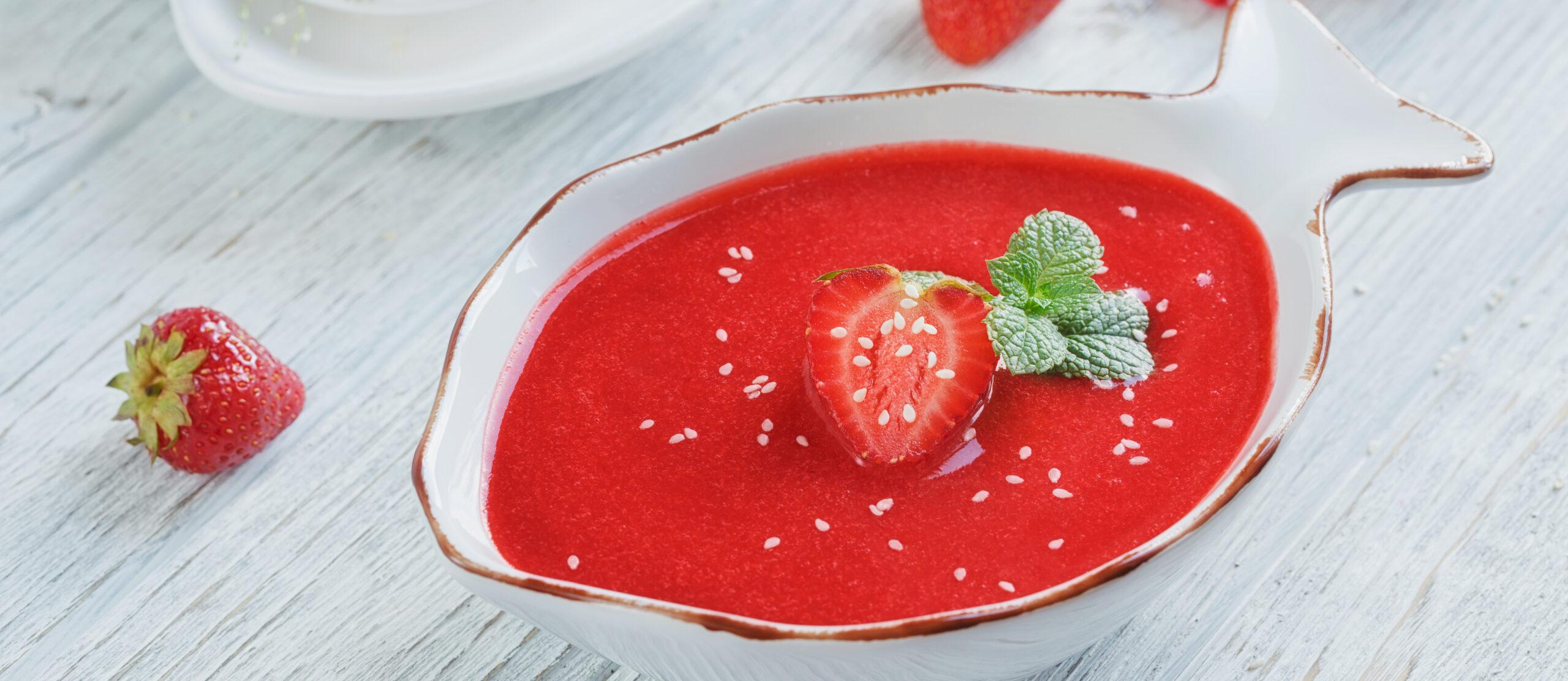 A bowl of strawberry soup gazpacho with mint