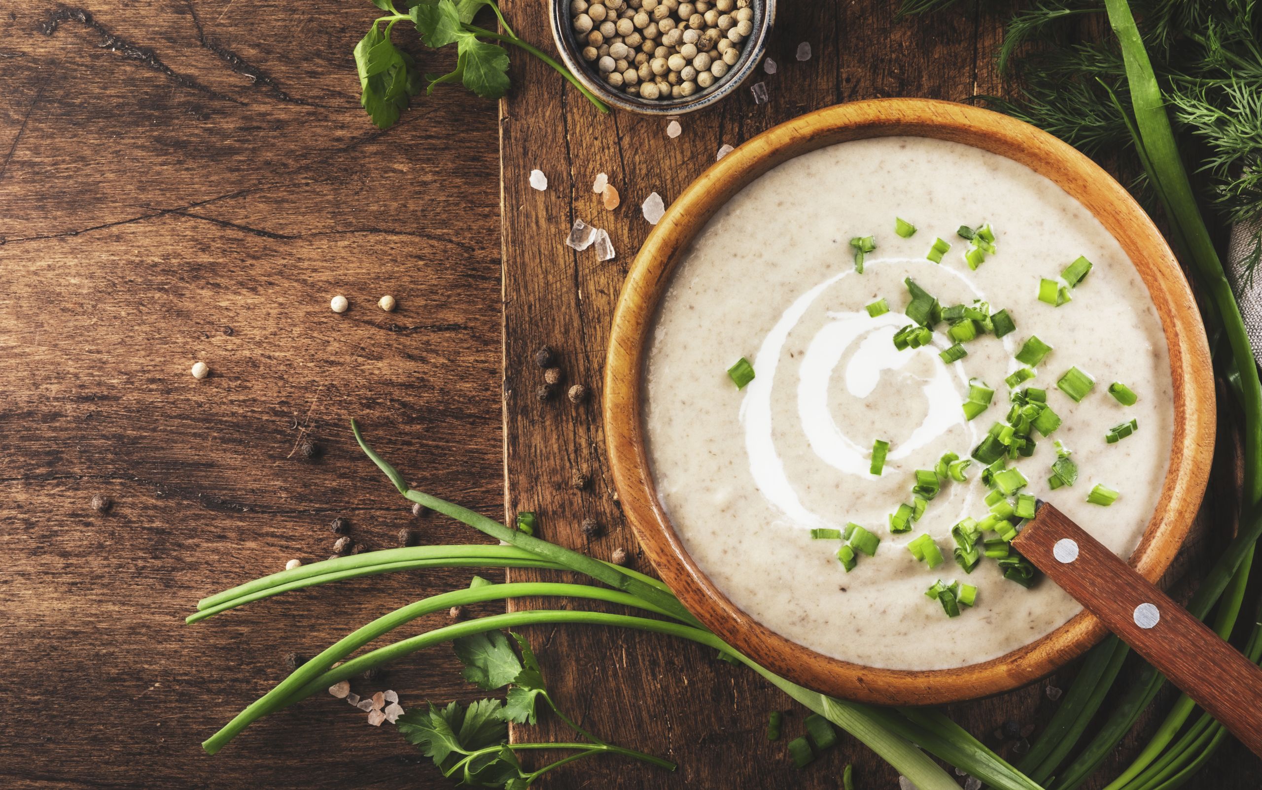 Creamy Mushroom Soup with croutons, spices and chives on rustic